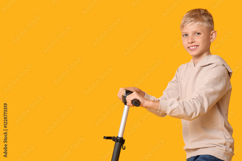 Cute boy with modern electric kick scooter on yellow background Cute boy with modern electric kick scooter on yellow background