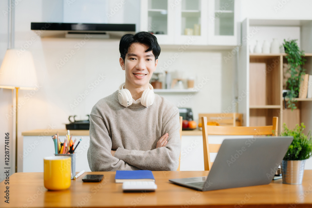 Young man using laptop while sitting at home. Young woman sitting in kitchen and working Young man using laptop while sitting at home. Young woman sitting in kitchen and working