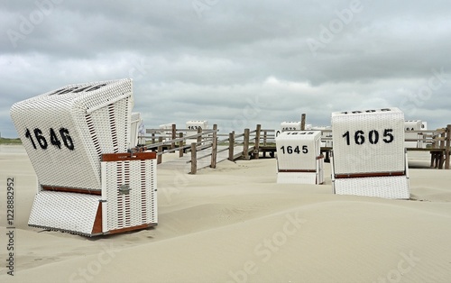 White beach chairs at the empty beach of Sankt Peter Ording, Schleswig-Holstein, Germany, Europe photo