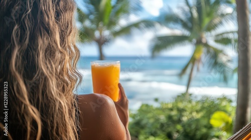 Woman enjoying a cold tropical fruit juice on a hammock, with palm trees in the distance photo