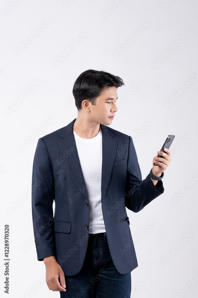 A man in a suit is smiling while looking at his cell phone A man in a suit is smiling while looking at his cell phone