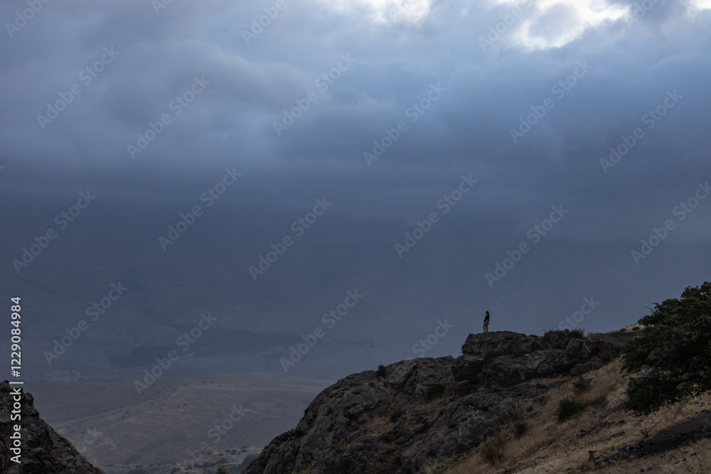 Tiny figure stands against a vast, dramatic sky filled with storm clouds. Nature's immensity and human insignificance. Storm, sky, silhouette, vastness. Tiny figure stands against a vast, dramatic sky filled with storm clouds. Nature's immensity and human insignificance. Storm, sky, silhouette, vastness.