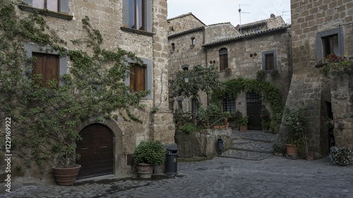 Old tufa buildings decorated with flowers in the hilltop village of Civita di Bagnoregio, Lazio, Italy, Europe
