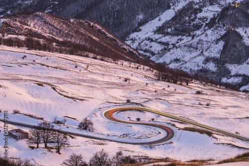 Hairpin turns and light trails of a car, winter sunset on Mount Nerone, Monte Nerone in the Apennines, Marche, Italy, Europe photo