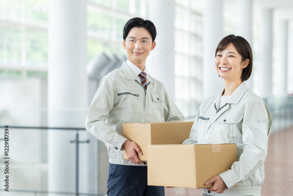 荷物を持つ作業員のスタッフ 荷物を持つ作業員のスタッフ