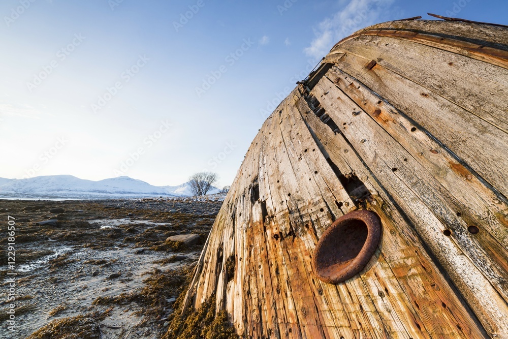 Shipwreck at sunrise and low tide near Tisnes Peninsula, Tromsoe, Norway, Europe Shipwreck at sunrise and low tide near Tisnes Peninsula, Tromsoe, Norway, Europe