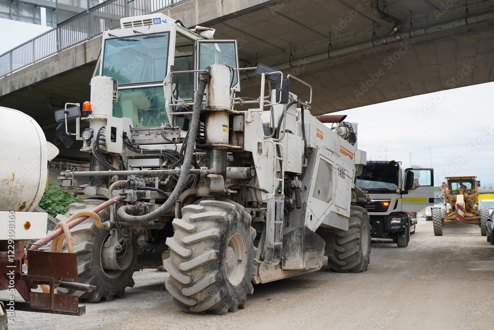 Heavy-duty asphalt recycler on a highway construction site, processing old pavement to create a stable foundation for a new asphalt layer Heavy-duty asphalt recycler on a highway construction site, processing old pavement to create a stable foundation for a new asphalt layer