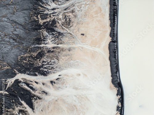 A milky-looking river creates abstract patterns in a river from a glacier.
