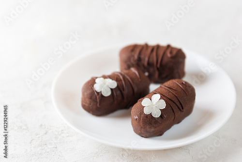 Vegan cheesecake candy bar with chocolate glaze, chocolate curd cheese on a plate. Selective focus.