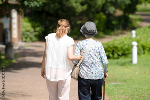 A park with good atmosphere with canal in Toyama Prefecture. Old woman in her 90s and Japanese woman in her thirties are walking around the park.