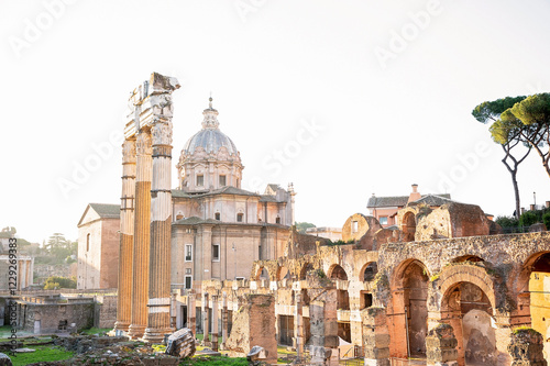 Ancient Roman ruins with a baroque church dome in Rome
