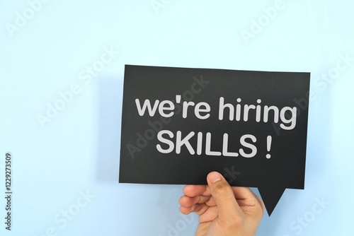 Obraz na płótnie Human hand holding yellow speech bubble with written phrase we are hiring skills. w salonie