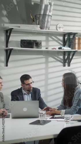 Colleagues And Clients Talking Strategy With Laptop And Tablet. In Creative Office Productive Coworkers Standing At The Table For Company Meeting. Teamwork And Scial Concepts photo