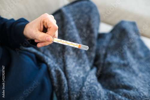 Measuring body temperature with a classic thermometer, health and medicine.
