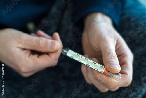 Measuring body temperature with a classic thermometer, health and medicine.
