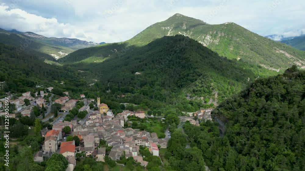Aerial view of a quaint mountain village in the south of France, surrounded by lush greenery under the summer sun. Aerial view of a quaint mountain village in the south of France, surrounded by lush greenery under the summer sun.
