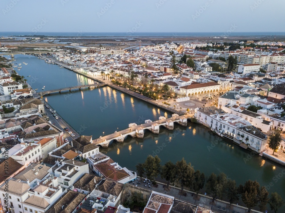 Obraz premium City view with roman bridge over Gilao river in old fishermen's town in the evening light, Tavira, drone shot, Algarve, Portugal, Europe