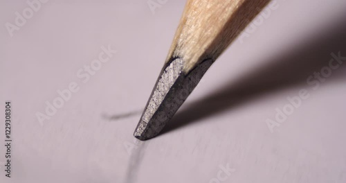 Close-up video of a pencil tip sketching fine graphite lines on textured paper. Captures intricate details of the drawing motion and wooden pencil material.