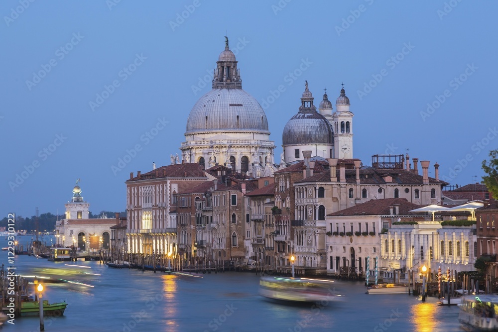 Fototapeta premium Grand Canal with light trails from water taxis, vaporettos in movement plus Renaissance architectural style palace buildings and Santa Maria della Salute basilica in Dorsoduro at dusk, Venice, Veneto, Italy, Europe