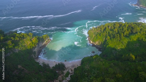 Drone view of coral hills on the edge of the sea with trees, coastal sand coral cliffs, and waves from the ocean at Sawangan Beach, Kebumen, Central Java photo