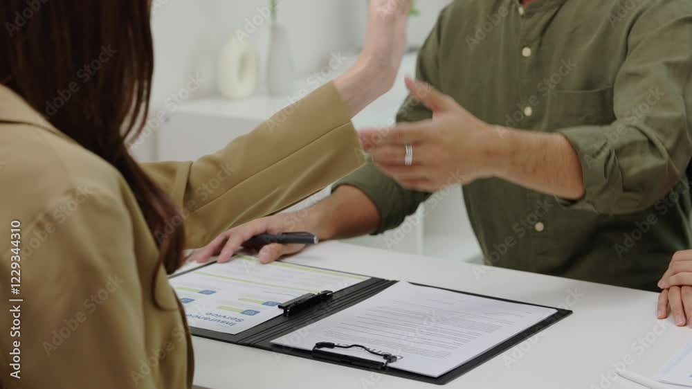 Asian couple handshake and sign contract financial documents with the guidance of  advisor at home,collaboration and thoughtful planning for financial success