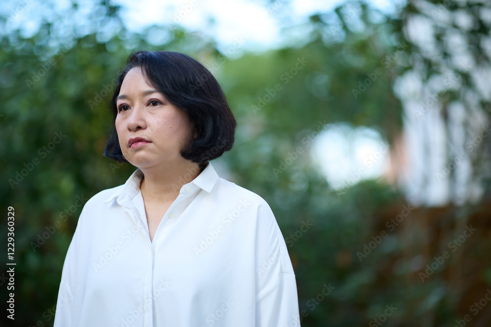 Portrait of smiling middle aged Asian business women in natural background Portrait of smiling middle aged Asian business women in natural background