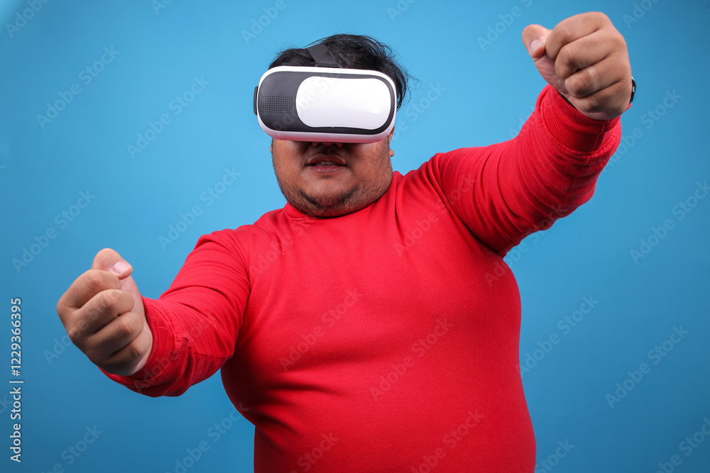 Naklejka premium Fat Man Wearing VR Glasses Gesture Driving A Car While Playing A Games Over Blue Studio Wall