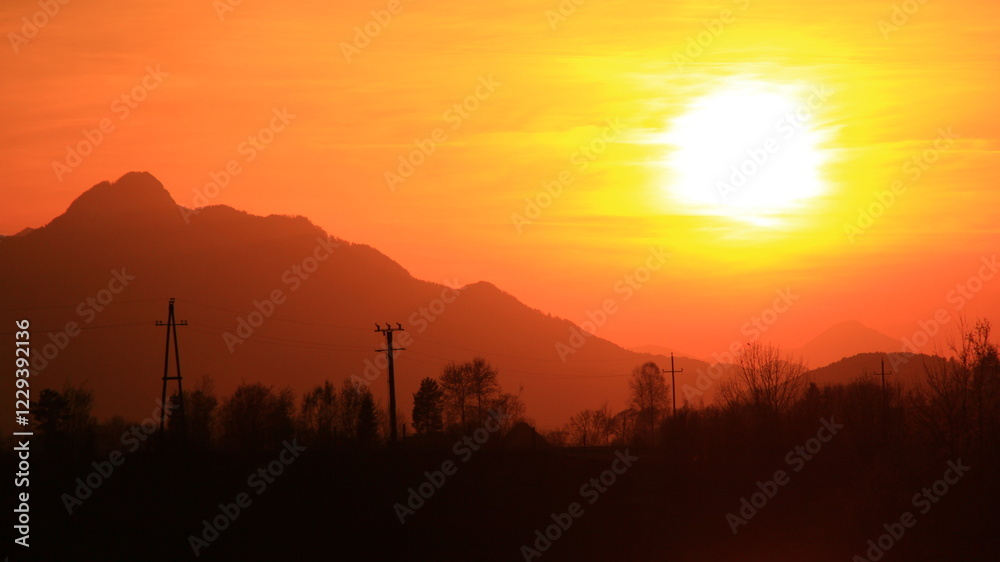 Sunset in the nature, near lake, among forests.
