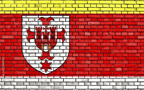 Flag of Kluczbork County painted on brick wall photo