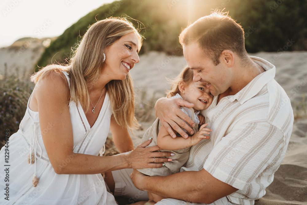 Family mom dad little girl hugging together at beach sunset Spain Family mom dad little girl hugging together at beach sunset Spain