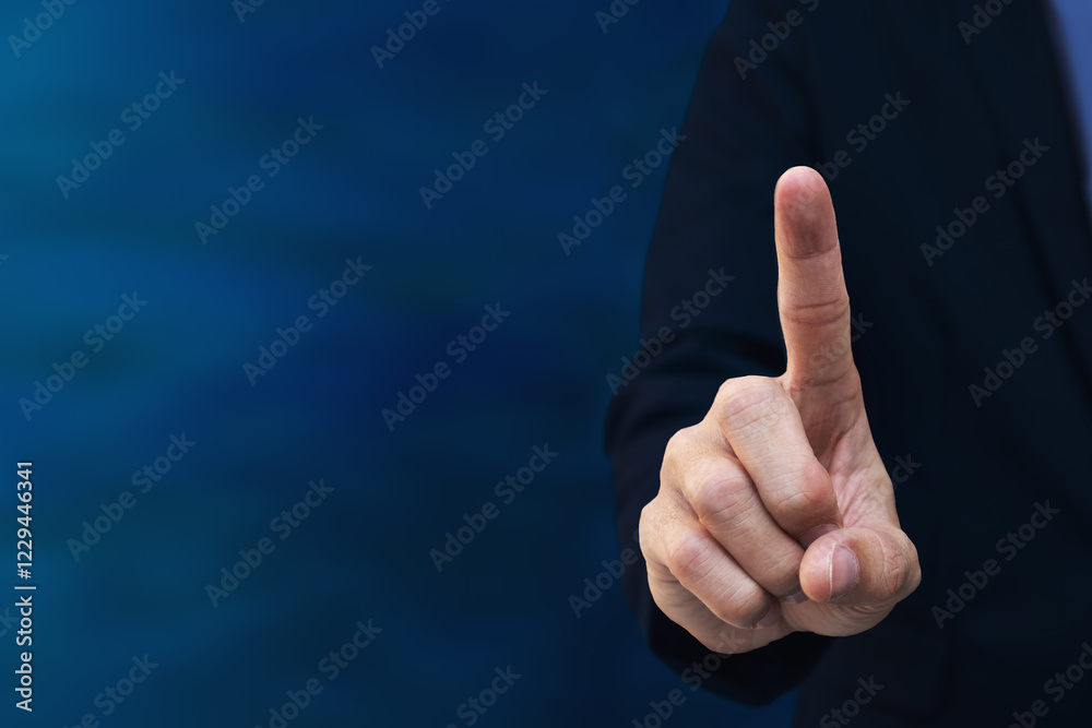 A close-up shot of a businessman's hand pointing on a blue background. A close-up shot of a businessman's hand pointing on a blue background.