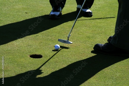 Two golfers putting on a golf course