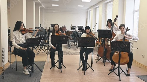 Musicians in string quintet deliver lively, heartfelt performance. Energy of live music enhances audience connection. Strings echo passion, creating atmosphere of unity and art