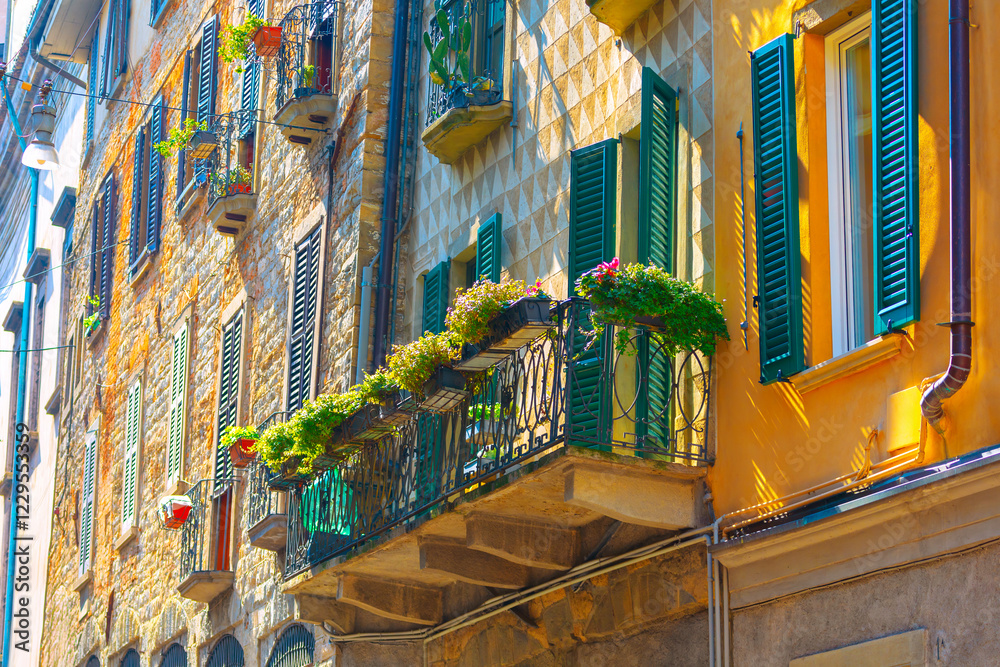 Vibrant and colorful street scene with row of buildings with various architectural styles. Buildings have balconies adorned with shutters and potted plants, creating picturesque and lively atmosphere