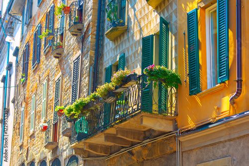 Obraz na płótnie Vibrant and colorful street scene with row of buildings with various architectural styles. Buildings have balconies adorned with shutters and potted plants, creating picturesque and lively atmosphere w salonie