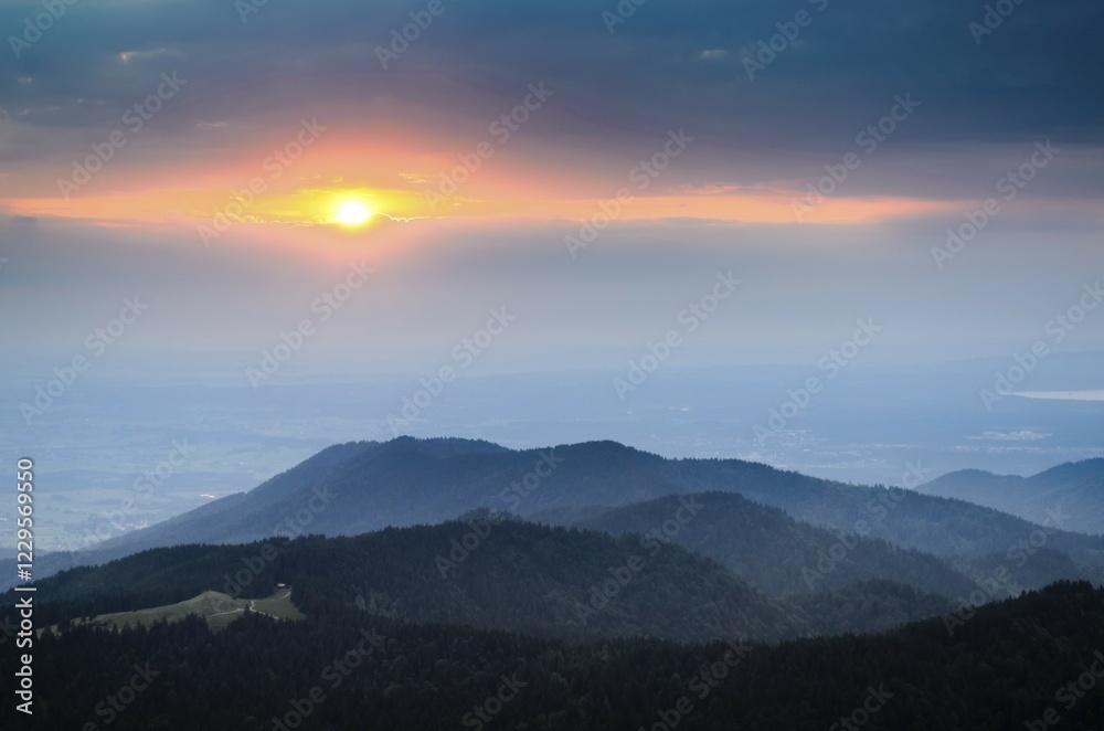 Obraz premium Sunset between layers of clouds, view from Brauneckgipfel mountain towards the west, Bavaria, Germany, Europe