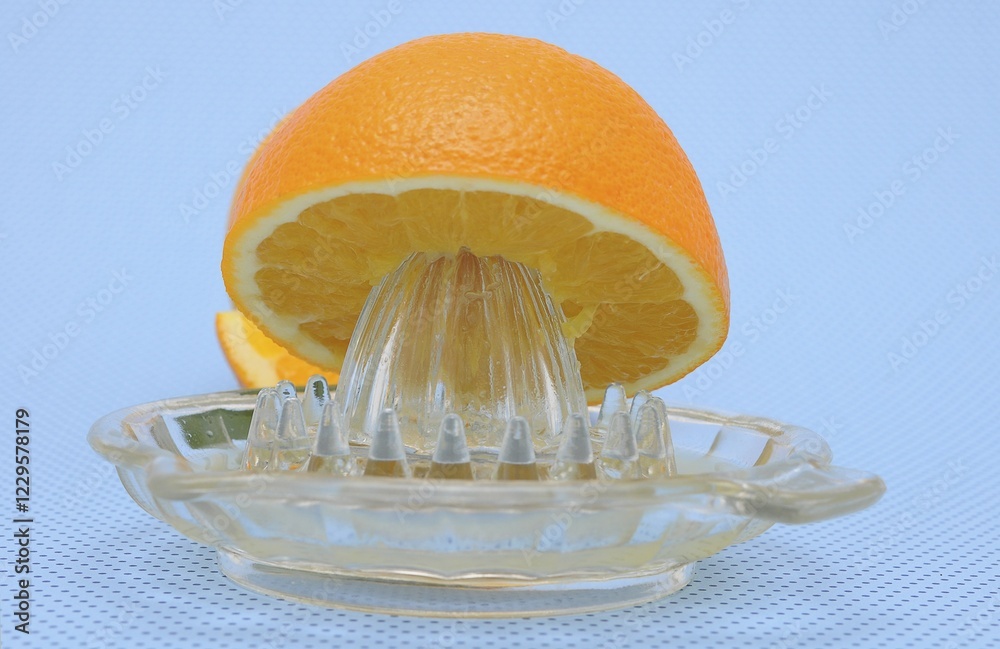 Orange juicer made of glass, half an orange