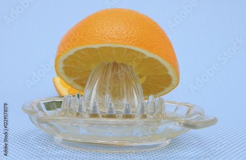 Obraz na płótnie Orange juicer made of glass, half an orange w salonie