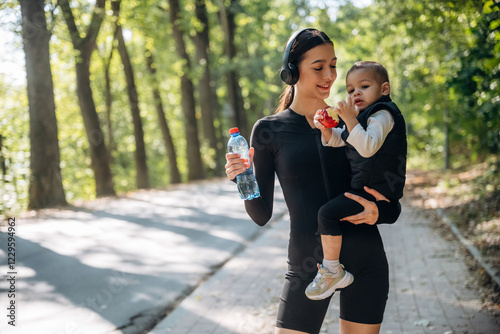 Standing together. Mother with her little son is outdoors. In sportive clothes
