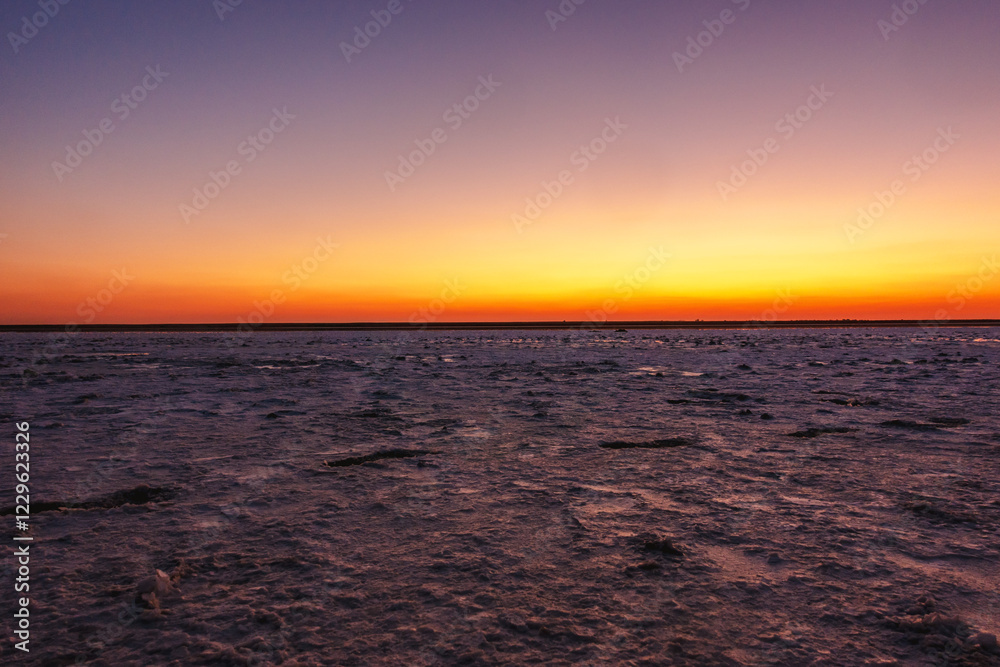 Obraz premium Landscape of a large salt lake at sunset.