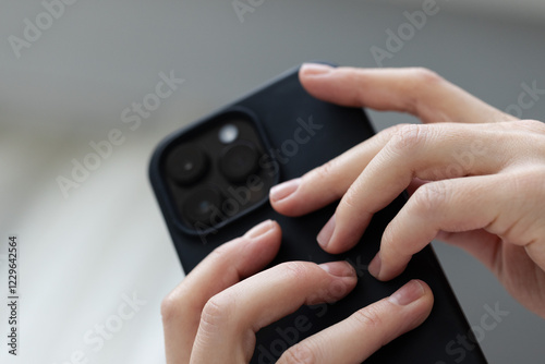 Wallpaper Mural Black smartphone in the female hands. Low angle, closeup. Torontodigital.ca