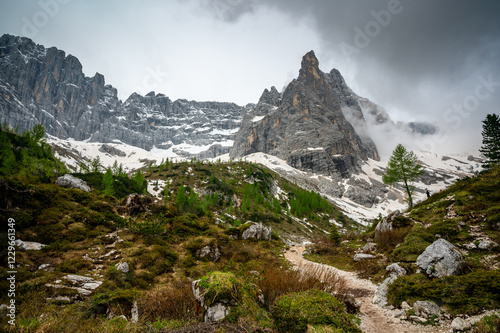 Obraz na płótnie Rocky hiking trail near Lago Sorapis in the Dolomites (Dolomiti, Dolomiten), Italy. The path runs alongside a small mountain stream, with massive boulders and peaks in the background w salonie