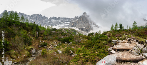 Obraz na płótnie Rocky hiking trail near Lago Sorapis in the Dolomites (Dolomiti, Dolomiten), Italy. The path runs alongside a small mountain stream, with massive boulders and peaks in the background w salonie
