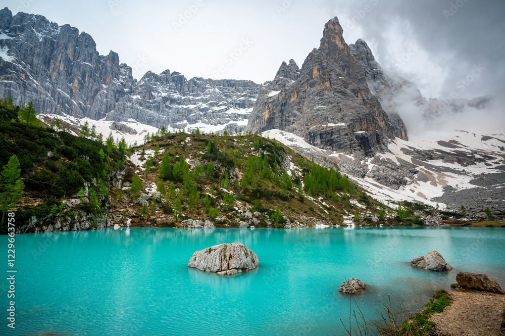 Panoramic view of Lago Sorapis in the Dolomites (Dolomiti, Dolomiten), Italy. The turquoise lake is surrounded by towering cliffs and mountains, a popular spot for hikers and nature lovers