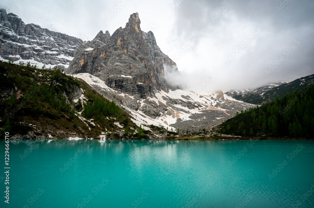 Panoramic view of Lago Sorapis in the Dolomites (Dolomiti, Dolomiten), Italy. The turquoise lake is surrounded by towering cliffs and mountains, a popular spot for hikers and nature lovers