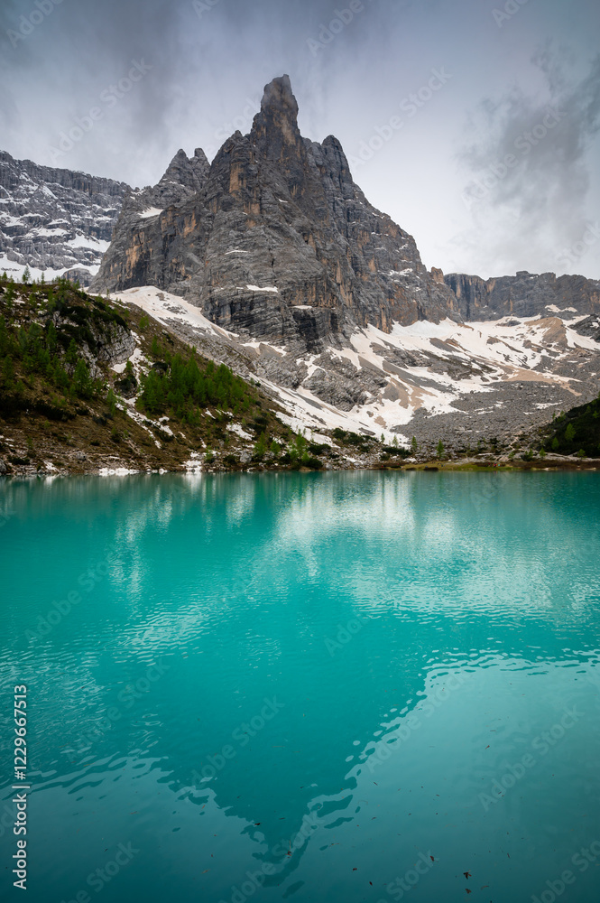 Panoramic view of Lago Sorapis in the Dolomites (Dolomiti, Dolomiten), Italy. The turquoise lake is surrounded by towering cliffs and mountains, a popular spot for hikers and nature lovers