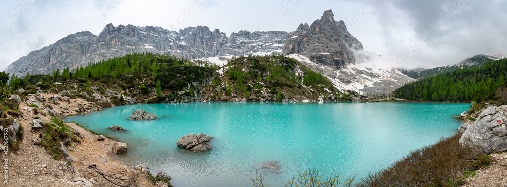 Panoramic view of Lago Sorapis in the Dolomites (Dolomiti, Dolomiten), Italy. The turquoise lake is surrounded by towering cliffs and mountains, a popular spot for hikers and nature lovers