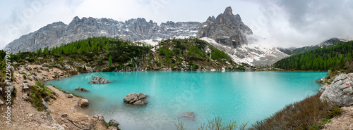 Obraz na płótnie Panoramic view of Lago Sorapis in the Dolomites (Dolomiti, Dolomiten), Italy. The turquoise lake is surrounded by towering cliffs and mountains, a popular spot for hikers and nature lovers w salonie