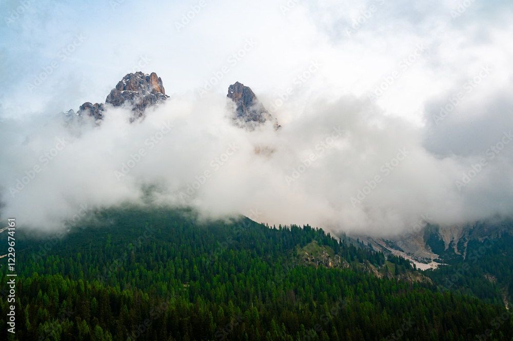 Mountain trail in the Dolomites (Dolomiti, Dolomiten), Italy, leading to Lago Sorapis. The path winds along rocky slopes with stunning views of valleys, forests, and peaks