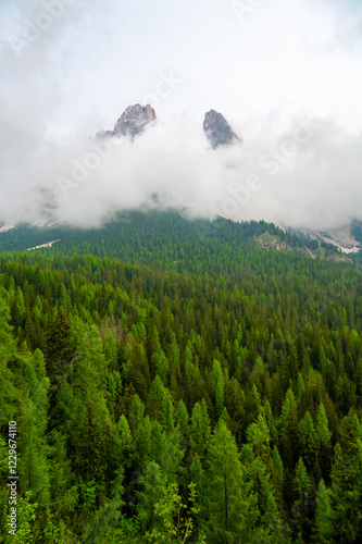 Mountain trail in the Dolomites (Dolomiti, Dolomiten), Italy, leading to Lago Sorapis. The path winds along rocky slopes with stunning views of valleys, forests, and peaks